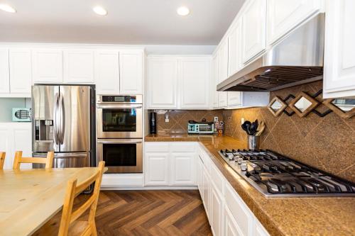 a kitchen with white cabinets and stainless steel appliances at Vineyard estate with pool and amazing views in Yucaipa
