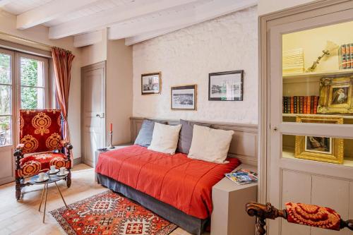 ein Schlafzimmer mit einem Bett mit einer roten Decke in der Unterkunft Chateau de Lourdes in Saint-Méloir-des-Ondes