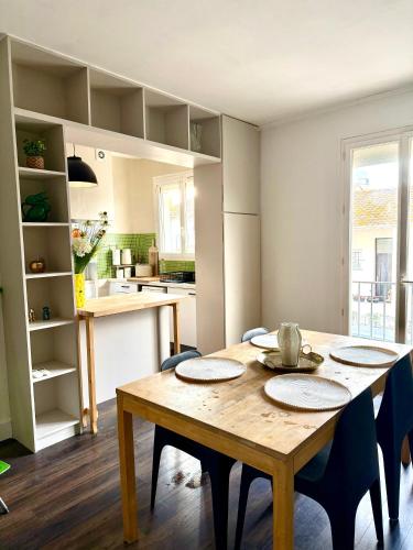 une cuisine et une salle à manger avec une table et des chaises en bois dans l'établissement Appartement Narbonne centre, à Narbonne