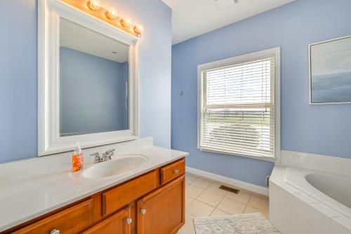 a bathroom with a sink and a mirror and a tub at Lake Cumberland Home with Hot Tub and Game Room in Burnside