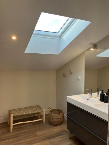La salle de bains est pourvue d'une lucarne, d'un lavabo et d'un banc. dans l'établissement La Grange 6 personnes, à Boulazac