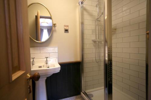 a bathroom with a sink and a shower with a mirror at Pont y Pair Inn in Betws-y-coed