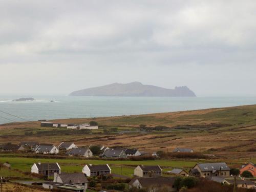 a group of houses on a hill next to the ocean at Barr na hAille in Dunquin