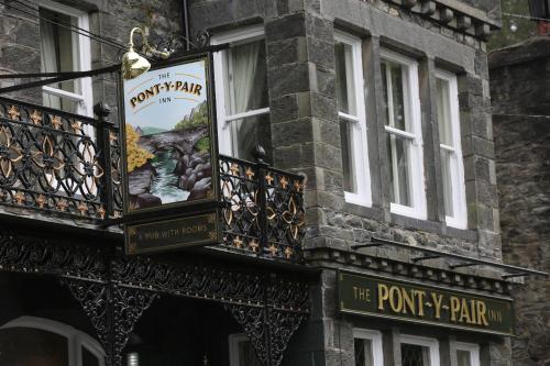 a sign on the side of a building with a window at Pont y Pair Inn in Betws-y-coed