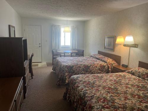 a hotel room with two beds and a table at Aurora Inn in Aurora