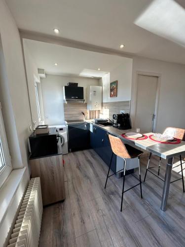 une cuisine avec une table et des chaises dans une pièce dans l'établissement Appartement F2 meublé, à Dunkerque