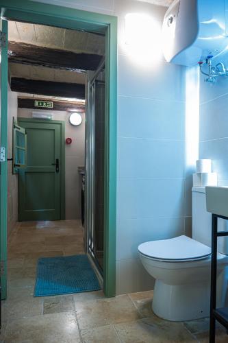 a bathroom with a toilet and a green door at Casa San Carlo 'Premium' in Valletta