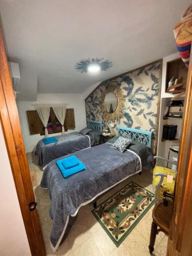 a bedroom with two beds and a couch at Casa rural en Buendía -la Galera con 4 dormitorios in Buendía