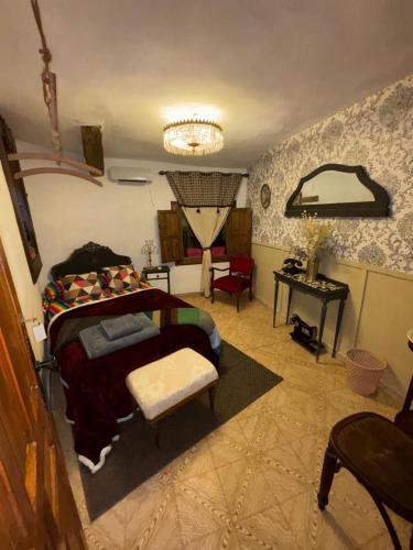 a bedroom with a bed and a chandelier at Casa rural en Buendía -la Galera con 4 dormitorios in Buendía