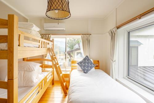 a bunk room with two bunk beds and a window at Togari Inn Suites in Iiyama