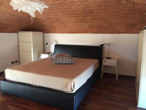 a bedroom with a bed and a brick wall at Il mare negli occhi in Marina di Pisa