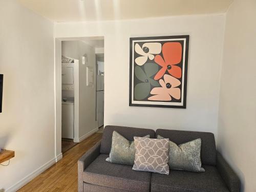 a living room with a couch and a painting on the wall at Espace Couronne by Hébergements DCL in Quebec City