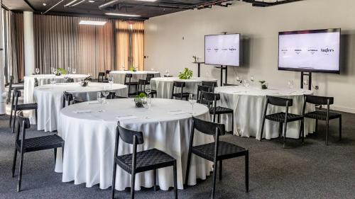 a conference room with white tables and chairs and a screen at Kimpton Angler’s Hotel South Beach by IHG in Miami Beach