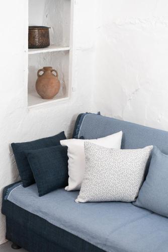 a blue couch with pillows in a room at Kimolos Heart Traditional Renovated House in Kimolos