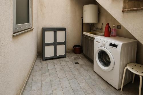 a laundry room with a washing machine in the corner at Mondello's Pearl in Mondello