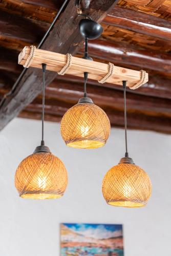 a group of three lights hanging from a ceiling at Kimolos Heart Traditional Renovated House in Kimolos