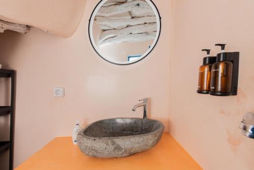 a bathroom with a stone sink and a mirror at Kimolos Heart Traditional Renovated House in Kimolos
