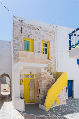a yellow door and stairs in a building at Kimolos Heart Traditional Renovated House in Kimolos