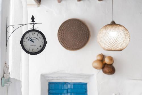 a clock and other decorations on a wall at Kimolos Heart Traditional Renovated House in Kimolos