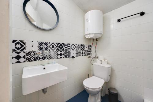 Un baño con inodoro, lavabo y espejo. en Cozy Nest Charming Loft in the heart of Varna, en Varna