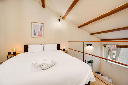 Una cama blanca grande en una habitación con ventana. en Cozy Nest Charming Loft in the heart of Varna, en Varna