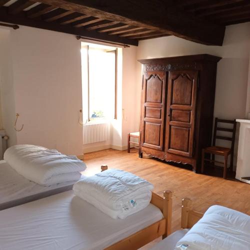 deux lits assis dans une pièce avec une fenêtre dans l'établissement Gite ancien presbytère, à Barrais-Bussolles