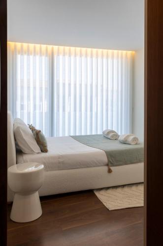 a bedroom with a bed and a large window at Terraço da Vila in Lousada