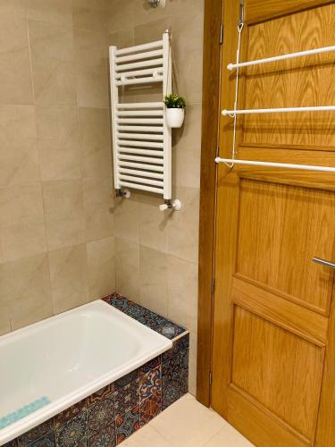 a bathroom with a bath tub next to a door at Arty Apartment - La Torre Golf Resort in Torre-Pacheco