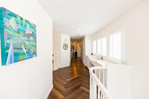 a hallway of a home with white walls and wood floors at Vineyard estate with pool and amazing views in Yucaipa