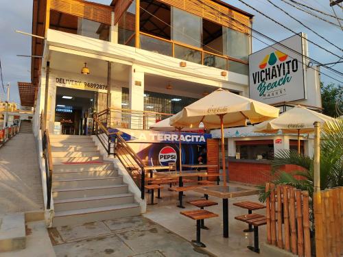 a restaurant with tables and umbrellas in front of a building at Prim Hotel Vichayito in Vichayito