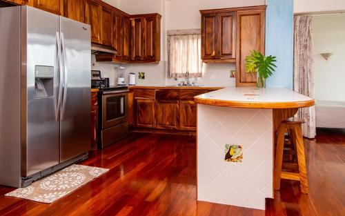 a kitchen with a stainless steel refrigerator and wooden cabinets at Lake Arenal Condos in Naranjos Agrios