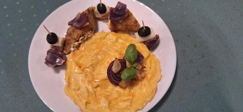 a white plate with food on a table at Filsdeger Ház - Central Rooms & Apartmans in Eger