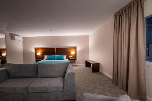 a hotel room with a couch and a bed at Howard Johnson Plaza & Convention Center Spa La Plata in La Plata