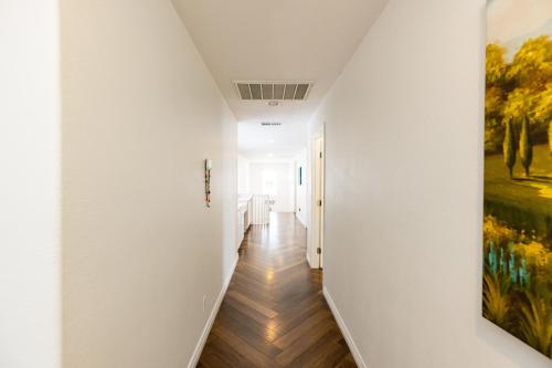 a hallway with white walls and a painting on the wall at Vineyard estate with pool and amazing views in Yucaipa