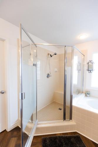 a bathroom with a shower and a tub and a sink at Vineyard estate with pool and amazing views in Yucaipa
