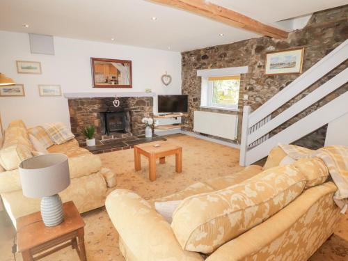 a living room with couches and a fireplace at Stable Cottage, Narberth in Narberth