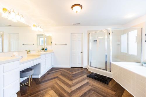 a white bathroom with two sinks and a shower at Vineyard estate with pool and amazing views in Yucaipa