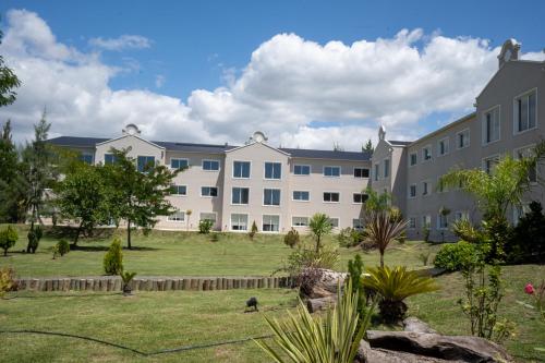 a large apartment building with a lawn in front of it at Howard Johnson Plaza & Convention Center Spa La Plata in La Plata