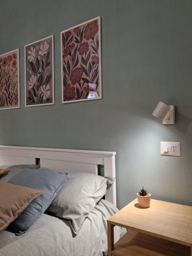 a bedroom with a bed and three pictures on the wall at Verso Maison in Gragnano