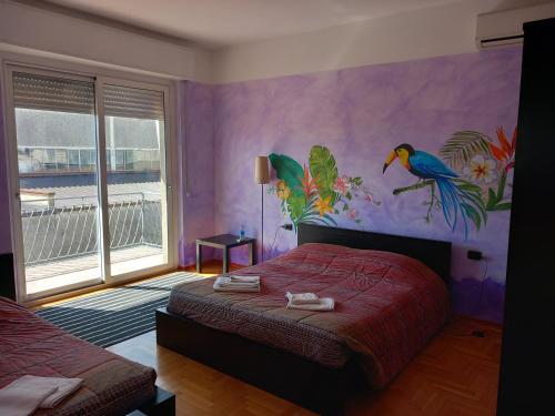 1 dormitorio con un mural de aves en la pared en VillAlbero B&B, en Inveruno