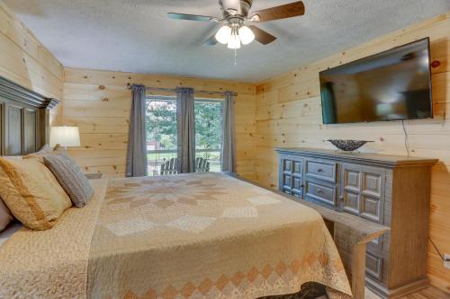 a bedroom with a bed and a flat screen tv at Mountain Retreat with Fire Pit in Flat Rock! in Flat Rock
