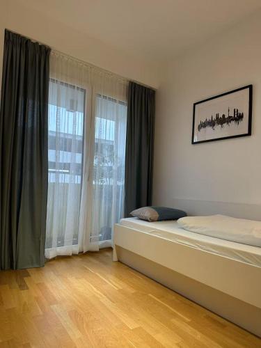 a bedroom with a bed and a large window at München Messe Apartment in Munich