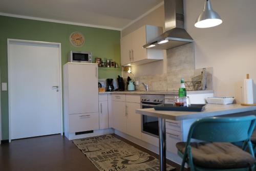 a kitchen with a white refrigerator and a counter top at Gartentraum Ferienwohnung in Pünderich