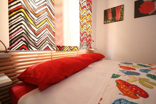 a bedroom with a bed with a red pillow and a window at B&B Santiago in Gela