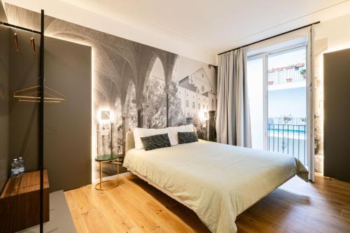 a bedroom with a bed and a large window at NILO RELAIS a san domenico maggiore in Naples