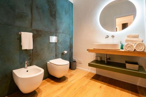 a bathroom with a sink and a toilet and a mirror at NILO RELAIS a san domenico maggiore in Naples