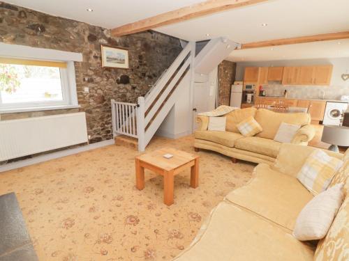 a living room with a couch and a table at Stable Cottage, Narberth in Narberth