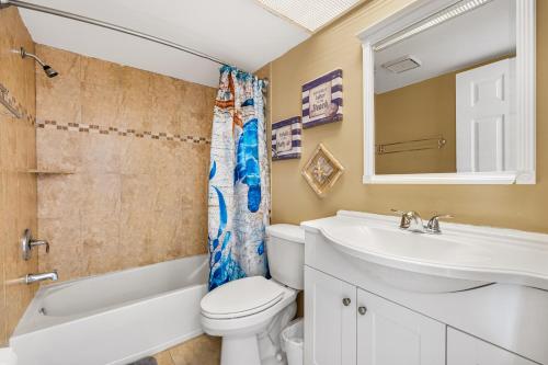 a bathroom with a sink toilet and a mirror at Lake House at the Beach C207 by Beachside Management in Siesta Key