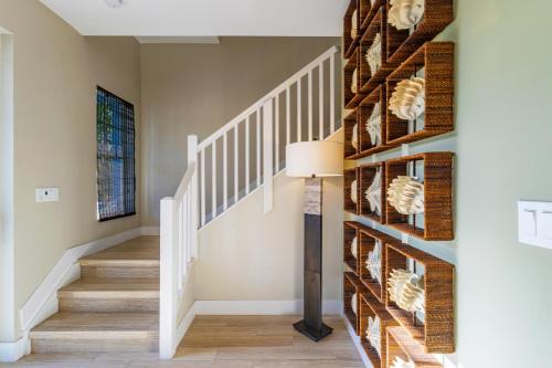 a hallway with a staircase with a wall of wine bottles at Hideaway #23 in Key Largo