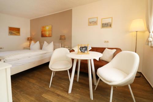 a hotel room with a bed and a table and chairs at Strandkojen in Trassenheide